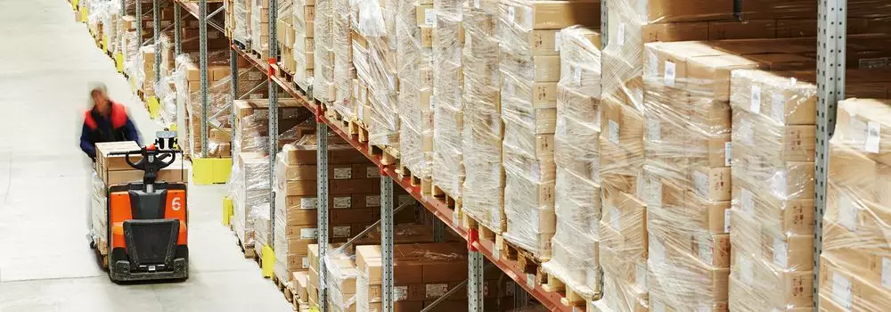 Qual a diferença entre armazenagem e cross docking? Na imagem, vemos mercadorias em centro logístico, que podem ser distribuídos seguindo os sistemas de cross docking ou armazenagem