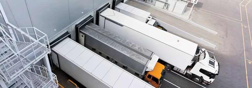 O que é sistema cross docking? Na imagem, vemos caminhões saindo do centro de distribuição para entrega, um dos passos do cross docking