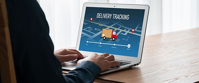 Qual a diferença entre TMS e ERP? Na imagem, homem utiliza software de TMS, que é específico para o gerenciamento do transporte de carga, enquanto o ERP integra diferentes áreas de uma empresa