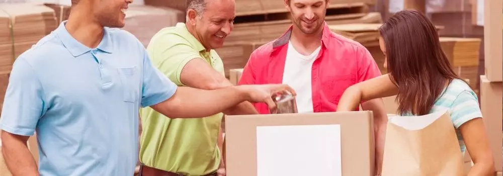 Quais as vantagens do Just in Time? Na imagem, pessoas abrindo mercadoria representa algumas vantagens do sistema: produção sobre demanda e redução de custos