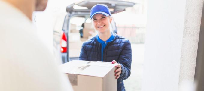logistica-de-distribuicao-eficiente Quais são as atividades da logística de distribuição? Na imagem, mulher entregando encomenda após chegar no destino final evidencia a importância da logística de distribuição para o transporte