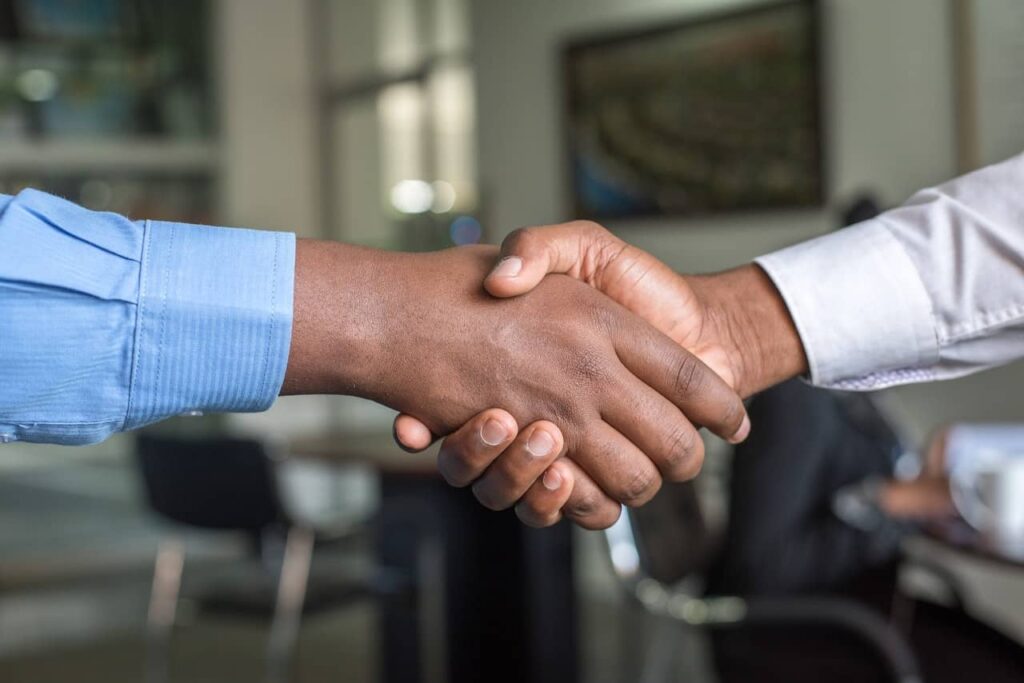 Como conseguir mais fretes? Na imagem, pessoas apertam a mão após fechar negócio em alusão a como vender mais fretes